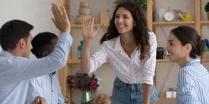 Happy excited two employees giving high five, celebrating team success
