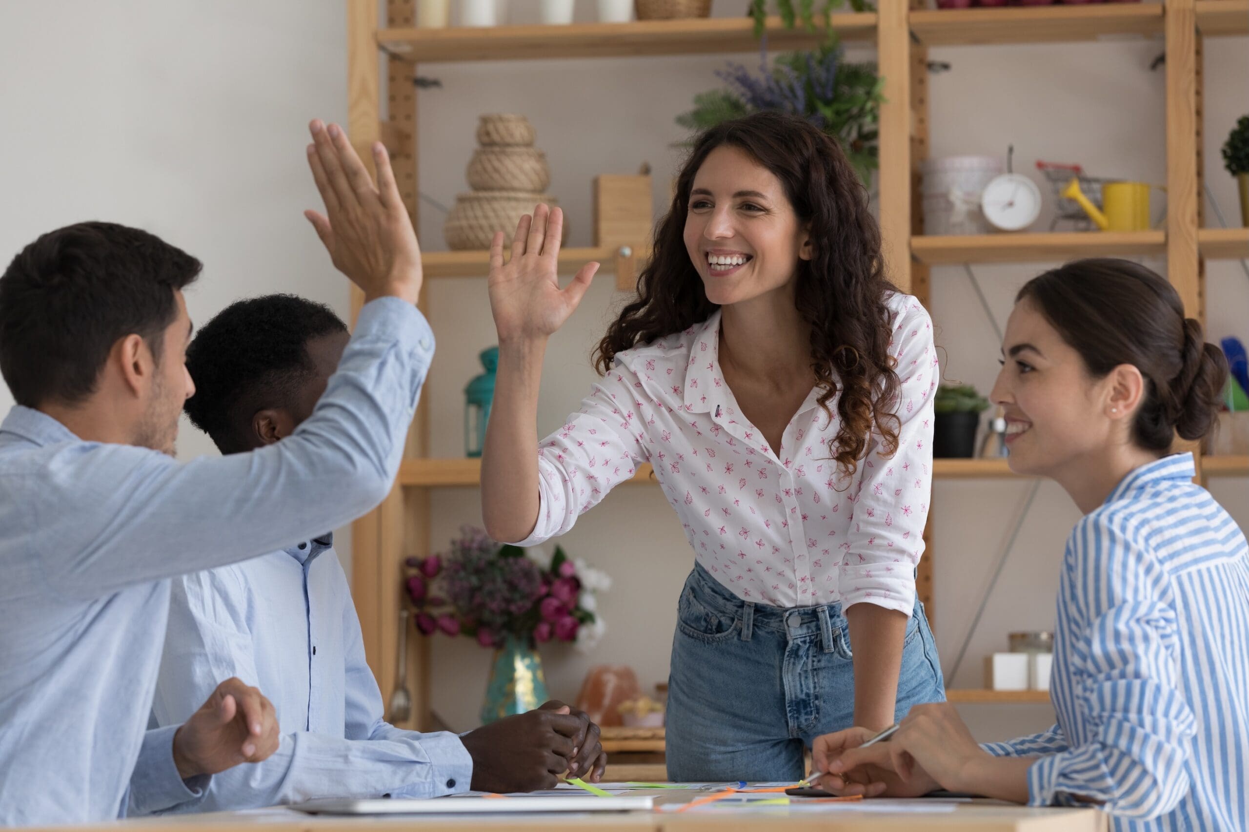 Happy excited two employees giving high five, celebrating team success