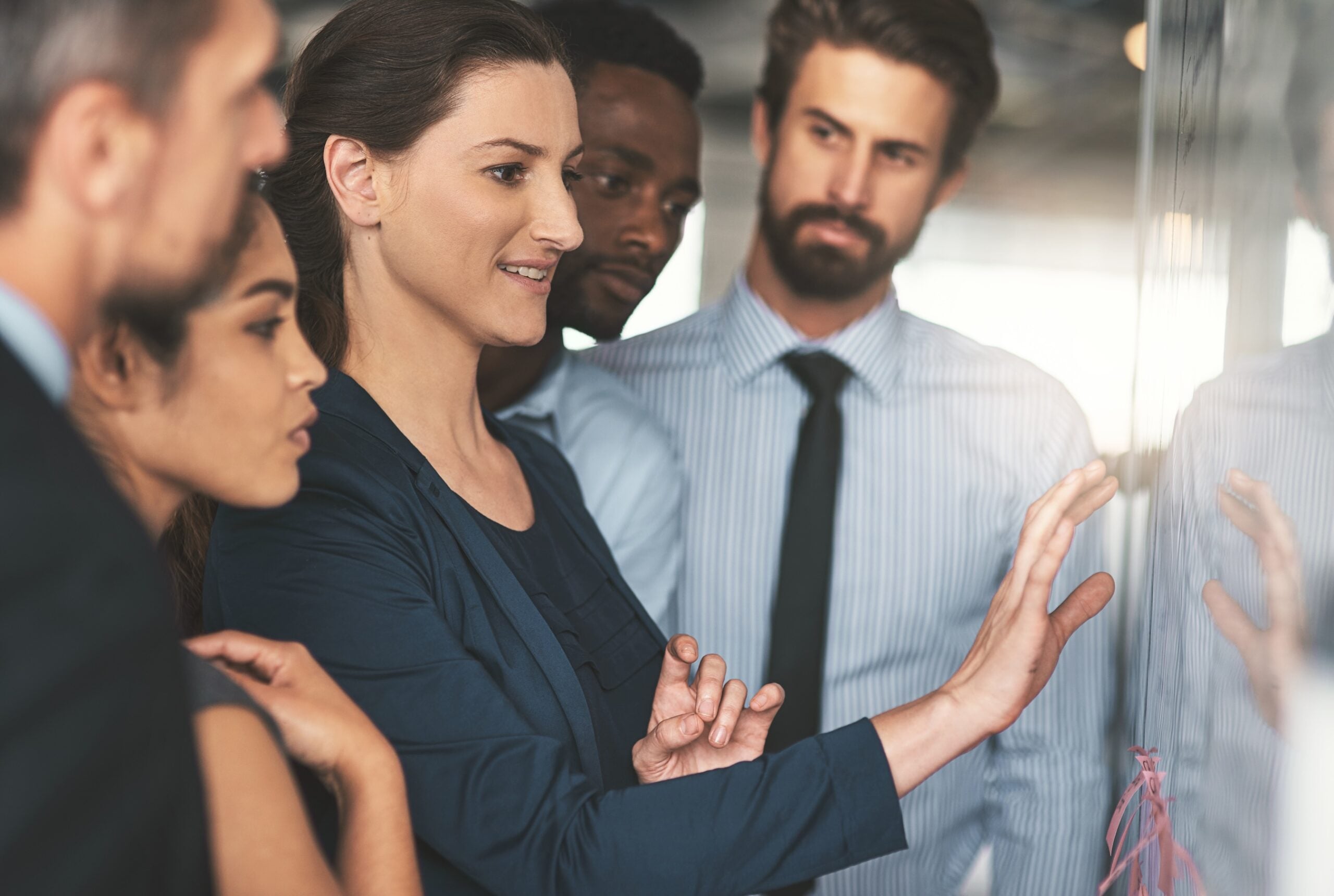 Shot of a group of businesspeople looking over plans on a whiteboard.
