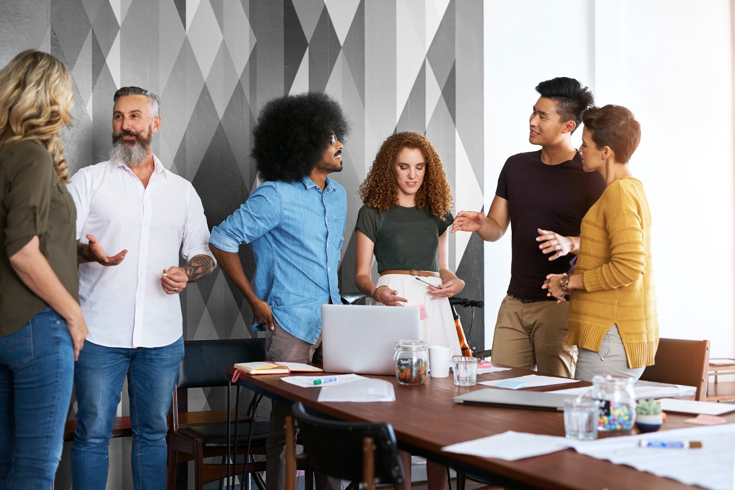 People, talking and meeting in startup for laptop or sharing strategy, campaign ideas and brainstorming.